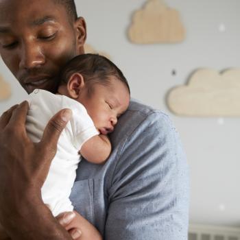 Durante a licença parental, pai cuida do filho recém-nascido