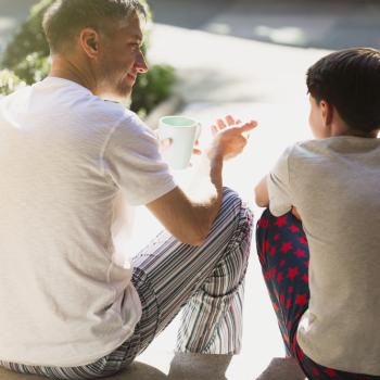 pai e filho sentados na calçada conversando