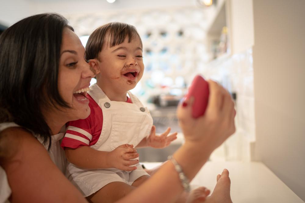 a imagem mostra uma mulher e um menino sorrindo, tirando uma selfie após ele ter comido chocolate.