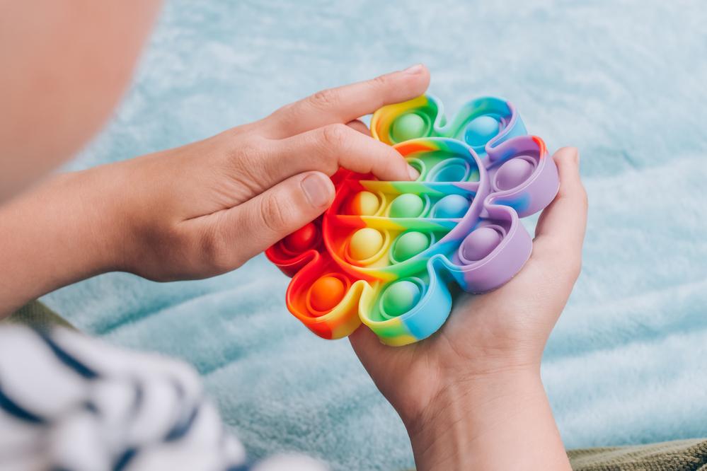 Criança brincando com um brinquedo sensorial chamado fidget toys