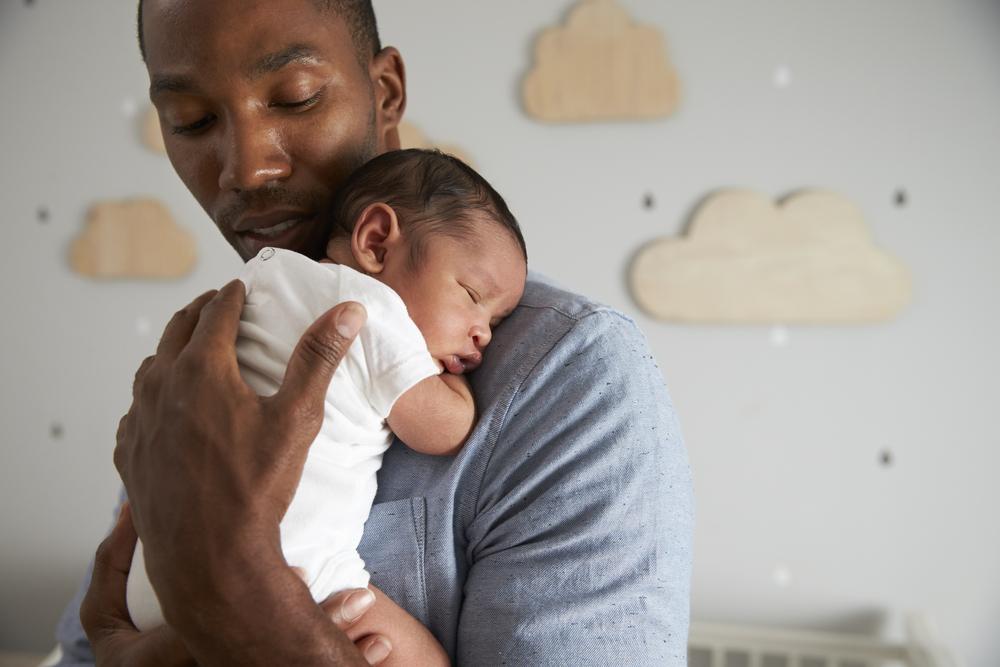 Durante a licença parental, pai cuida do filho recém-nascido