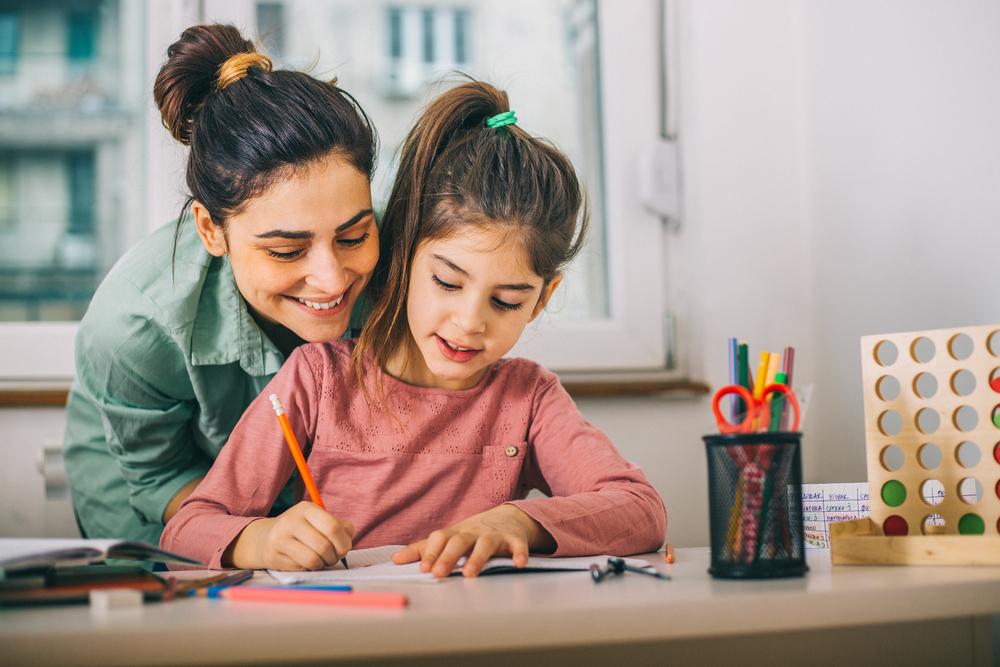 mãe ajudando filha a estudar